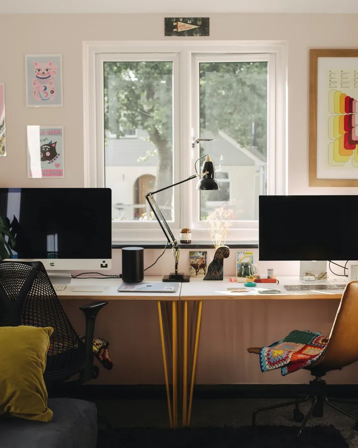 Bright studio workspace with two monitors by a window